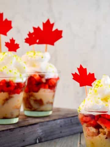 Canada Day mini cakes in cups with maple leaf decorations.