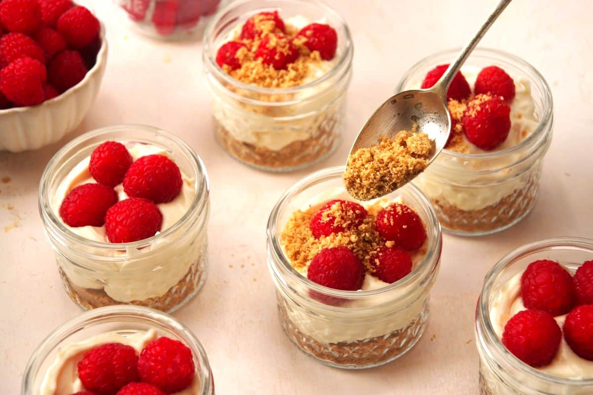 Raspberry cheesecake in a jar assembled in small jars.