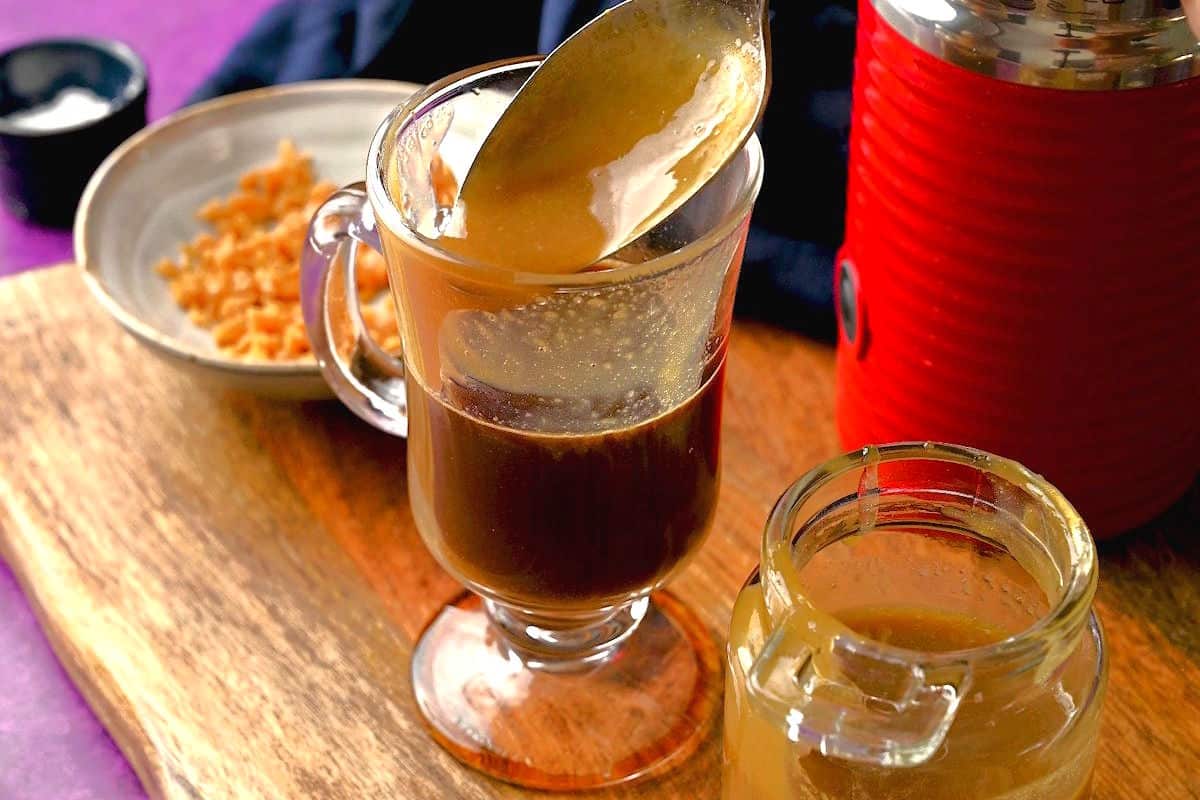 Caramel brulee sauce and espresso in clear coffee mug.