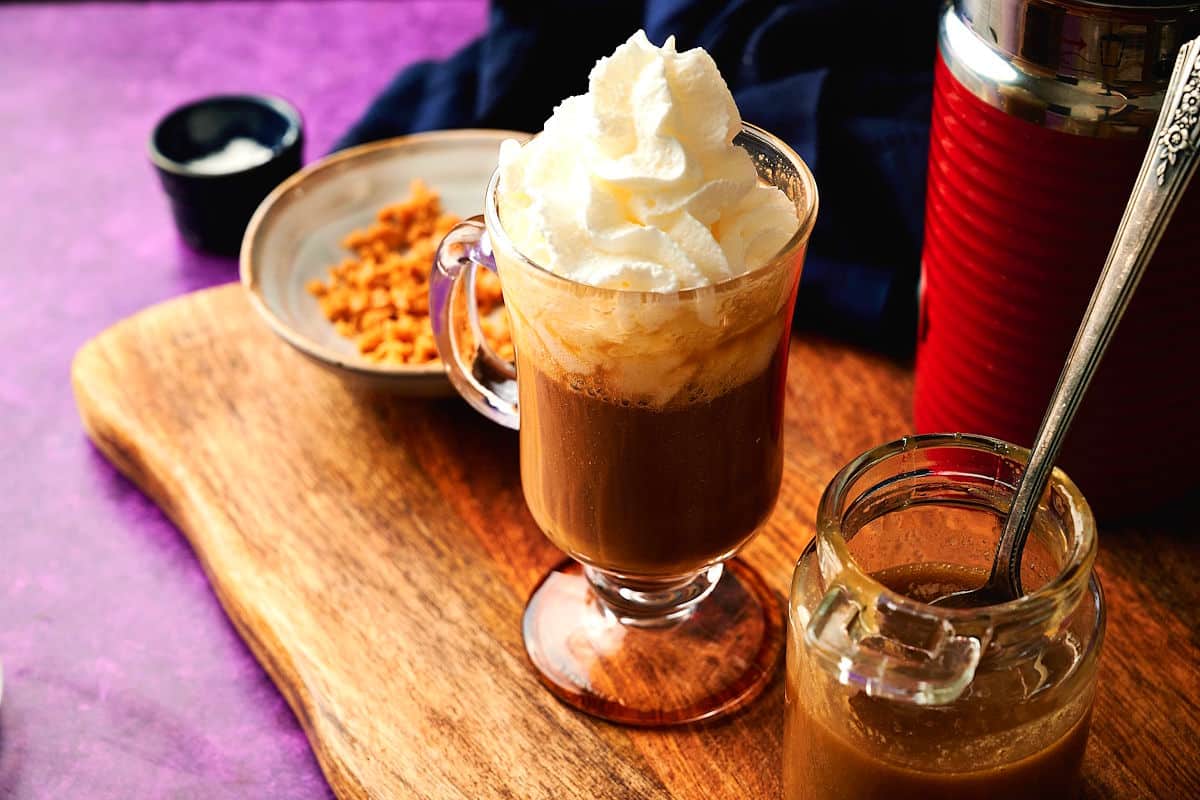 Caramel Brulee latte with whipped topping and caramel sauce on the side.