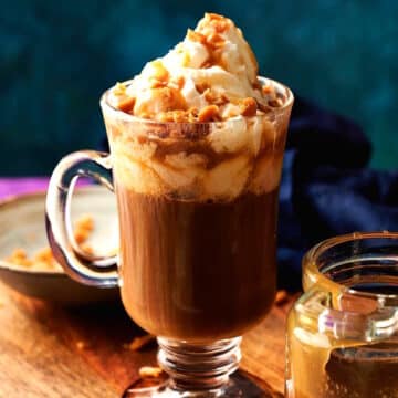 Caramel brûlée latte and sauce on blue background.