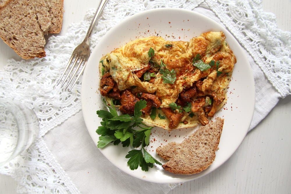 Chanterelle omelet on white plate with a side of toast.