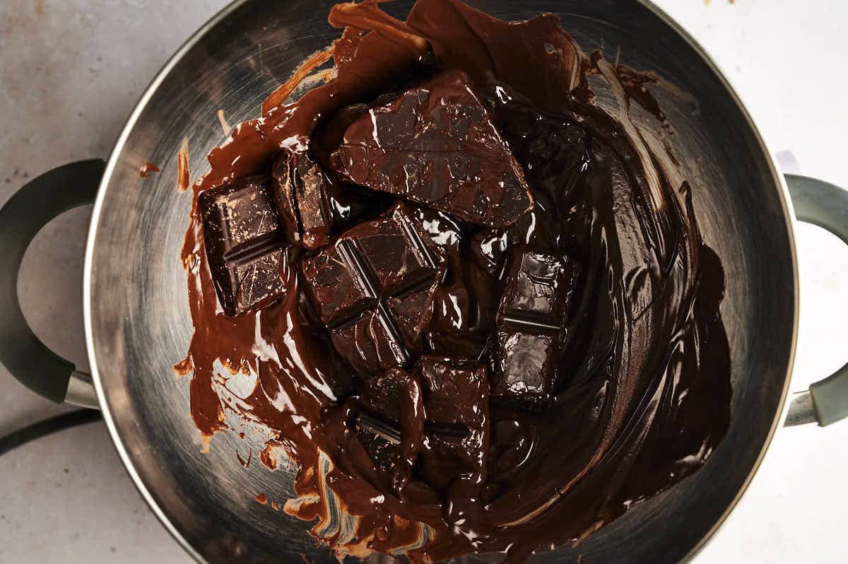 Dark chocolate melting in pot.