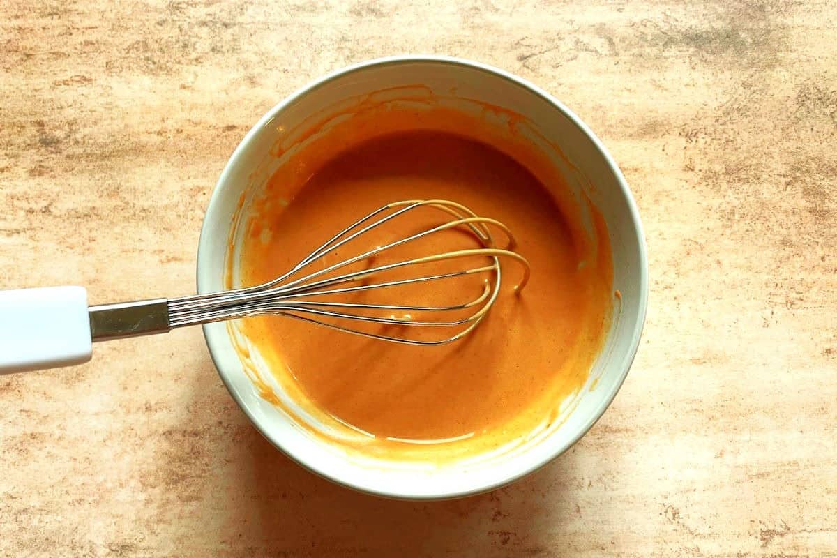 Burger sauce in bowl with whisk.