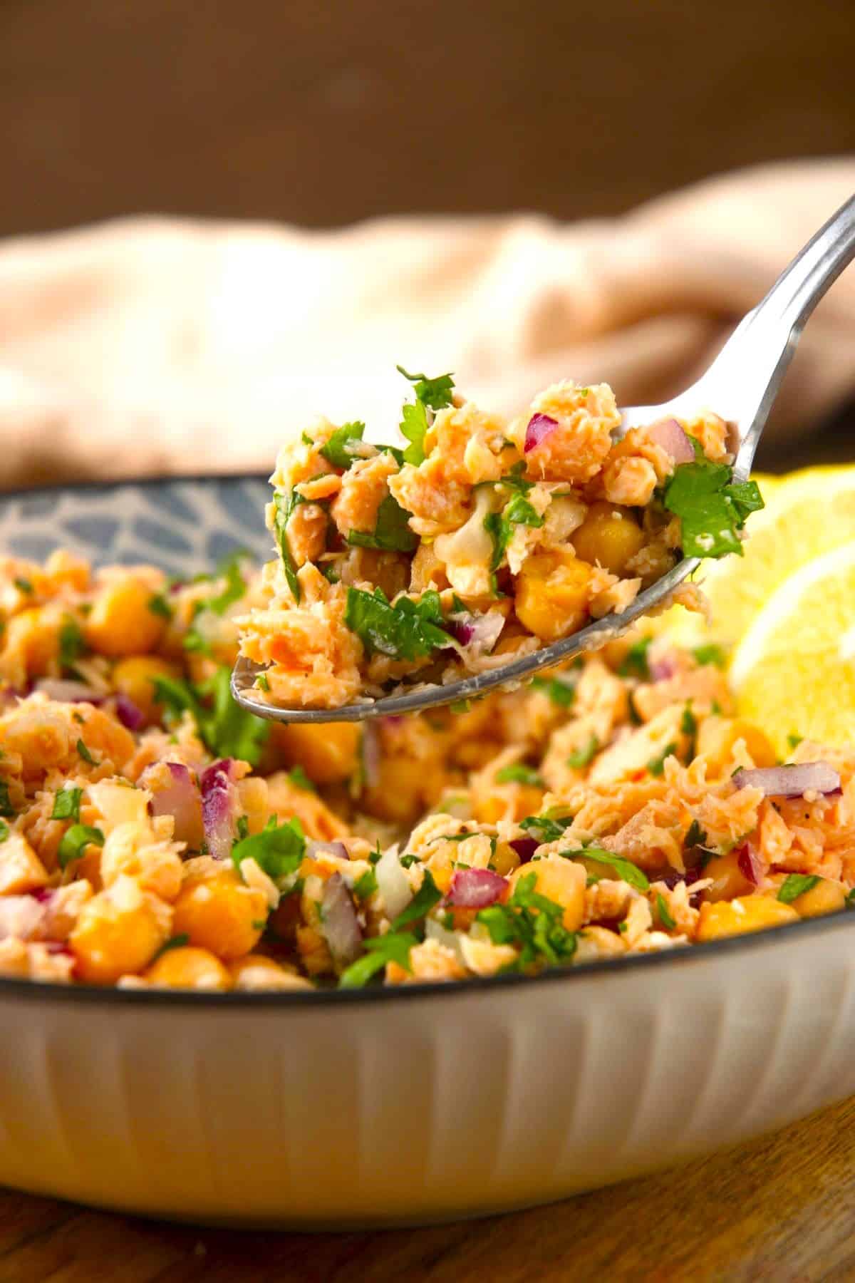 Chickpea and salmon salad on a spoon.