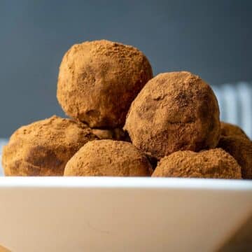 Chocolate truffles in a white dish.