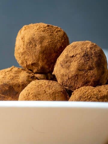 Chocolate truffles in a white dish.