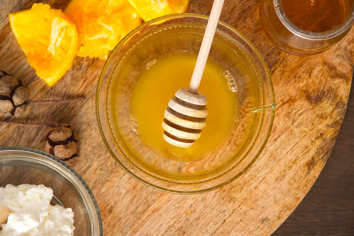Honey and orange juice in small glass bowl.