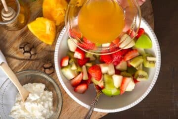 Fruit salad and orange juice in bowls.