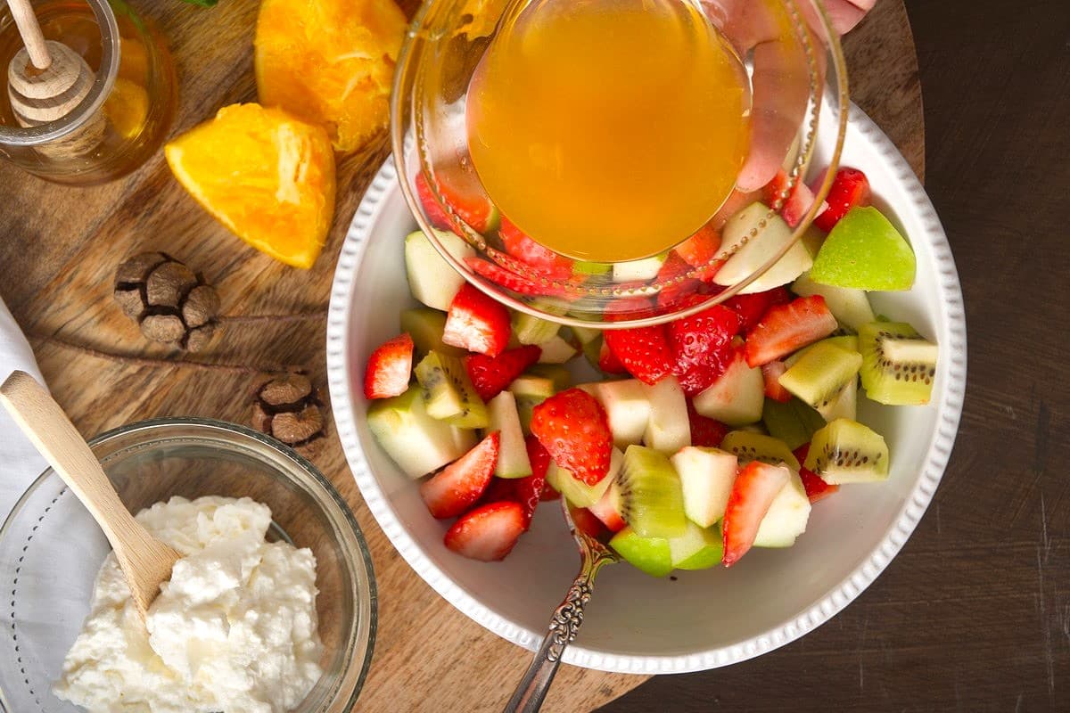 Fruit salad and orange juice in bowls.