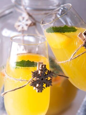 Christmas punch in champagne glasses with wooden snowflake decorations.