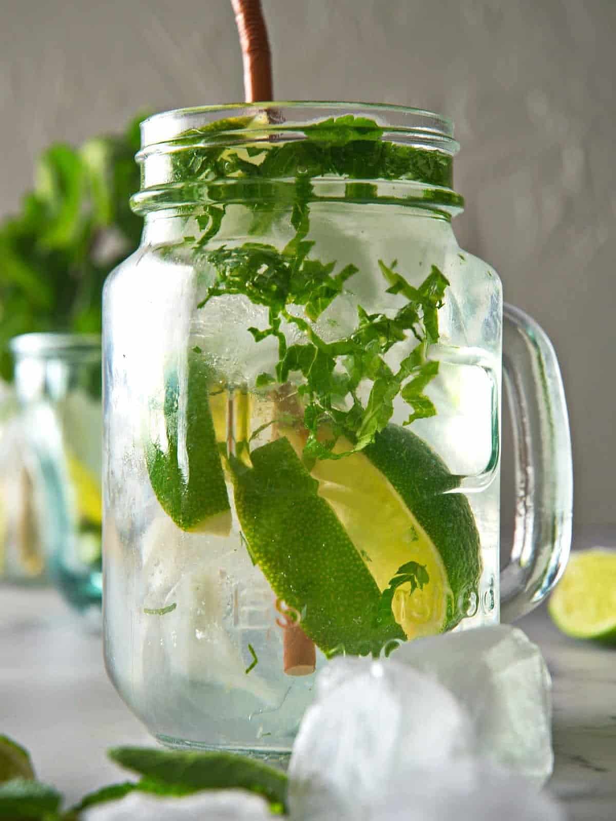 Classic mojito mocktail in glass with ice and straw.