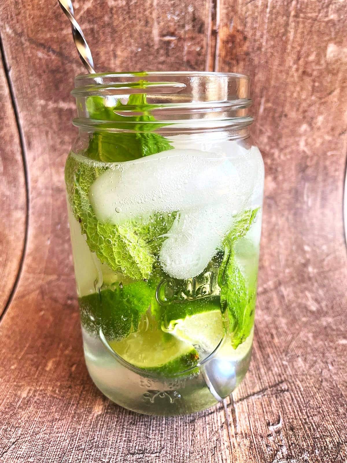 Mojito mocktail in glass getting stirred.