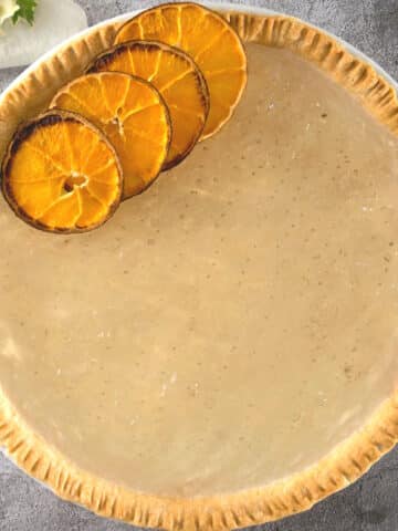 Clear pumpkin pie with dehydrated orange slices.