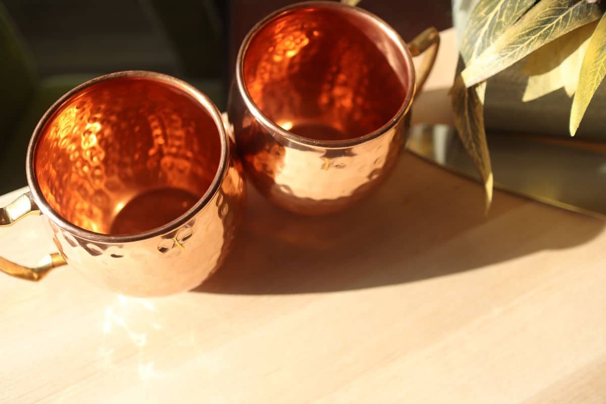 Copper mugs on wooden table.