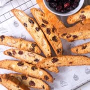 Cranberry biscotti scattered on baking rack.