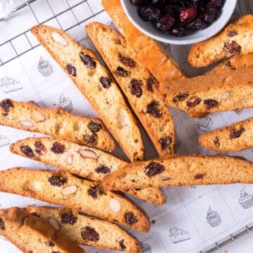Cranberry biscotti scattered on baking rack.