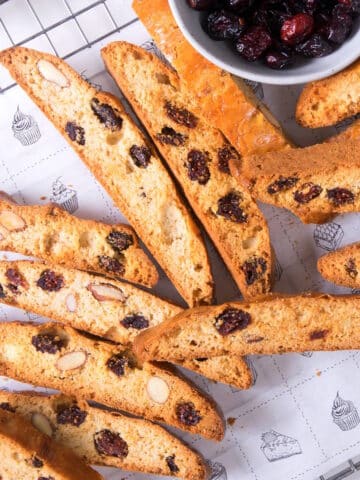 Cranberry biscotti scattered on baking rack.
