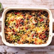 Creamy burrito casserole in white casserole dish.