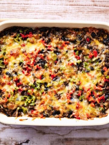 Creamy burrito casserole in white casserole dish.