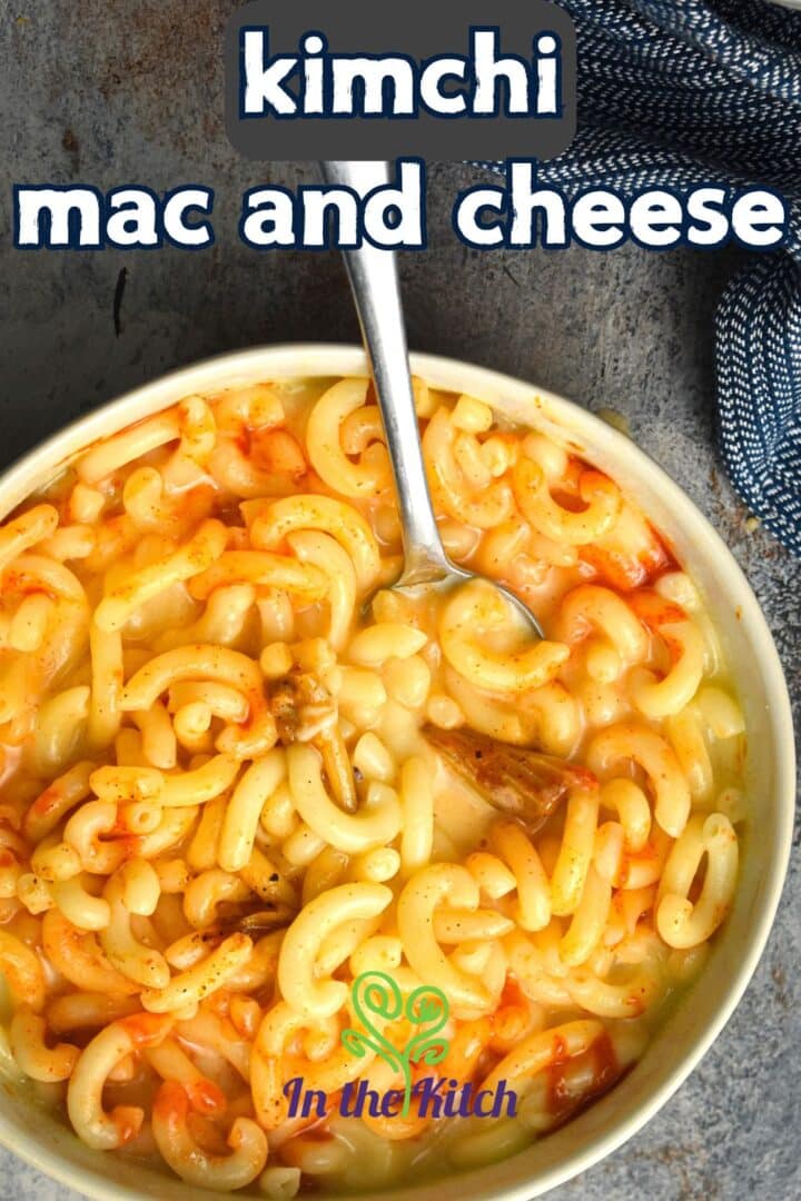 Kimchi mac and cheese in a bowl with spoon and text overlay that says 'kimchi mac and cheese'.
