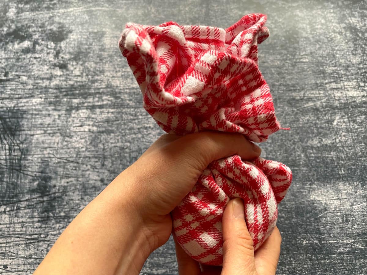 Hands holding towel with Spanish peanuts in it.