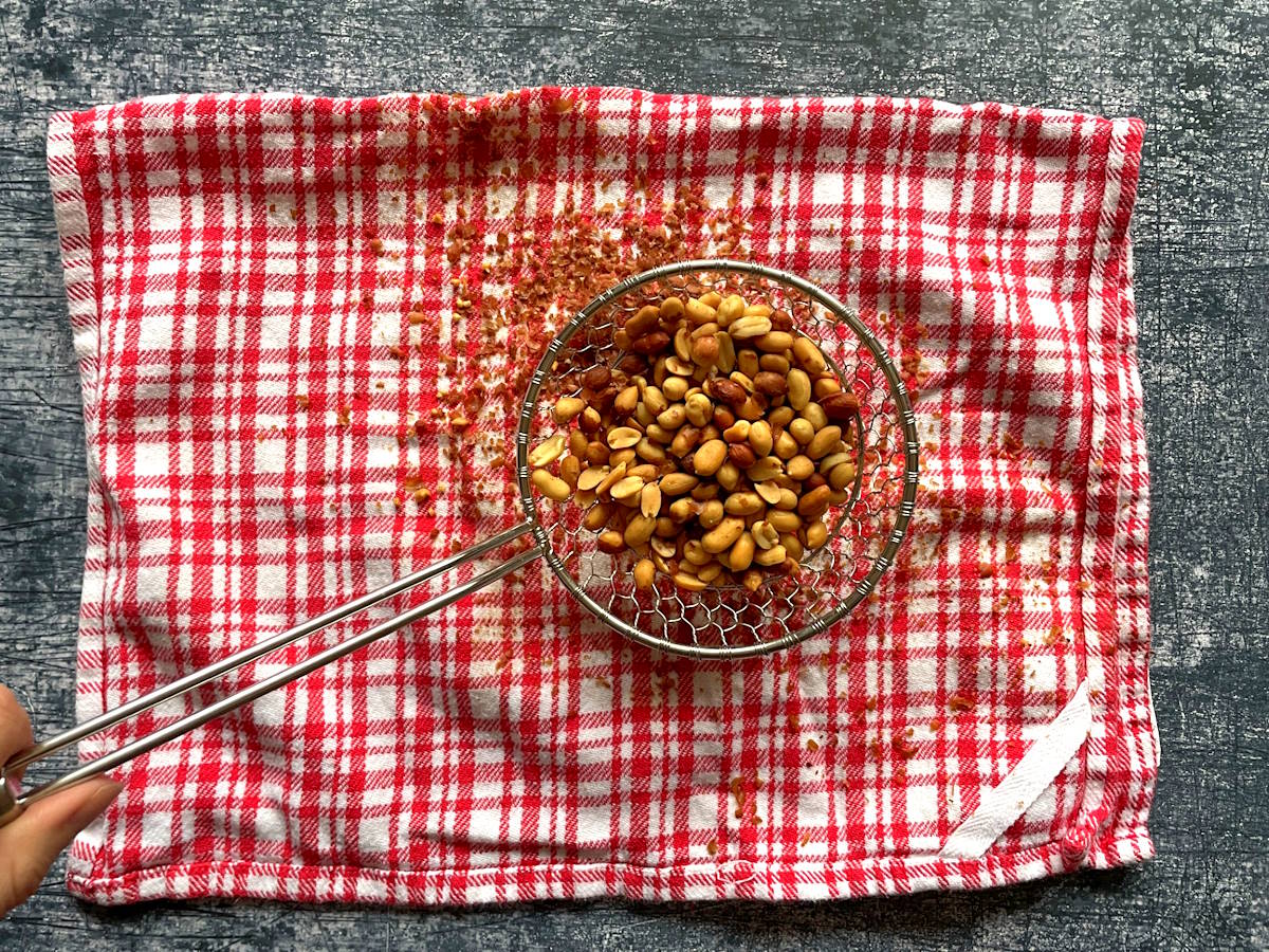 Spanish peanuts in strainer over kitchen towel.
