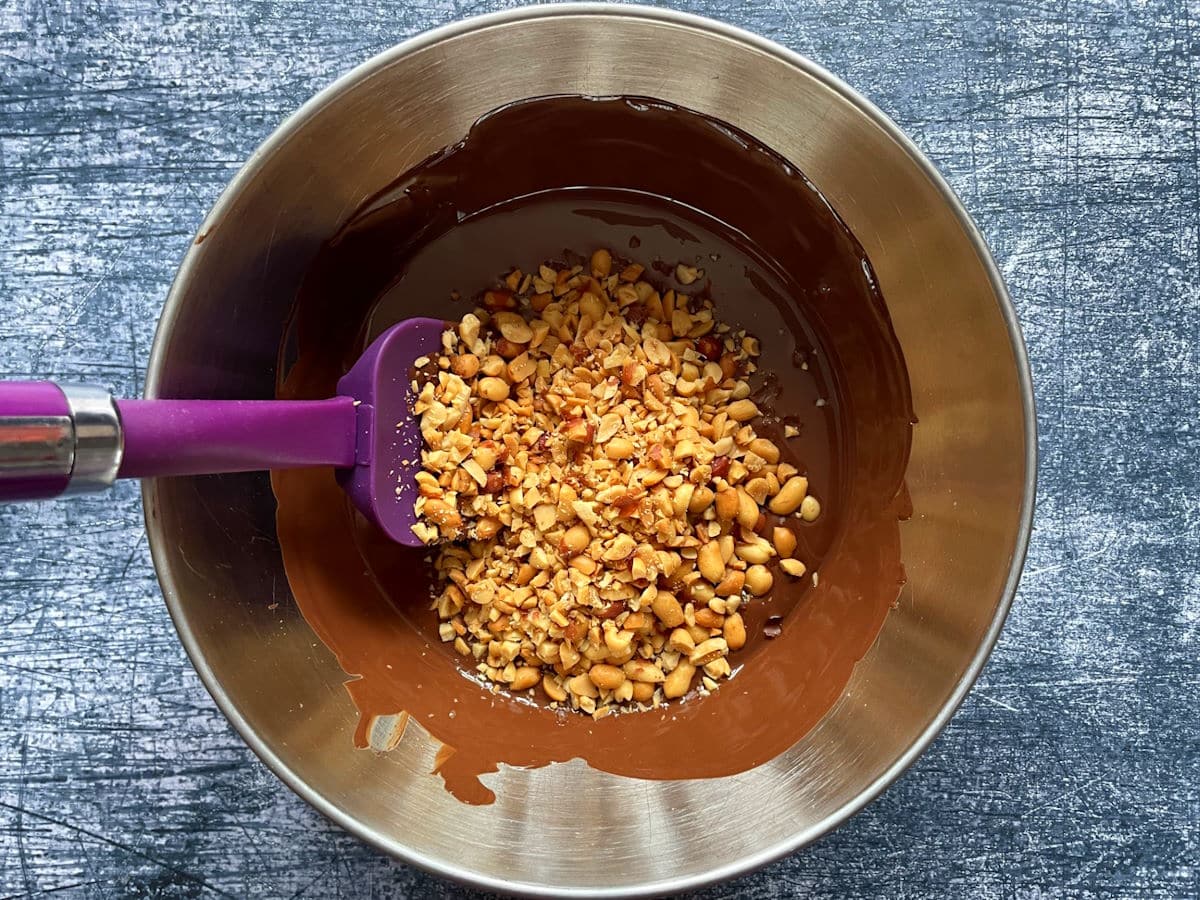 Melted chocolate and peanuts in bowl.