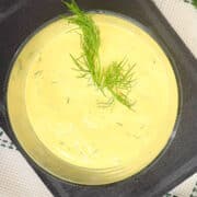 Dill dip in serving bowl with fresh dill on top.