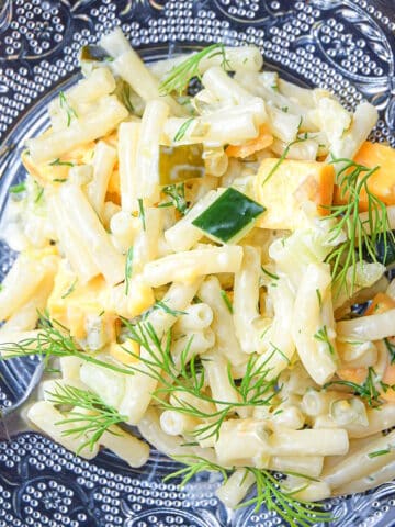 Dill pickle pasta salad on clear, glass plate.