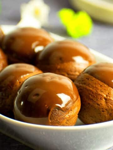 Chocolate covered donut holes on serving tray.