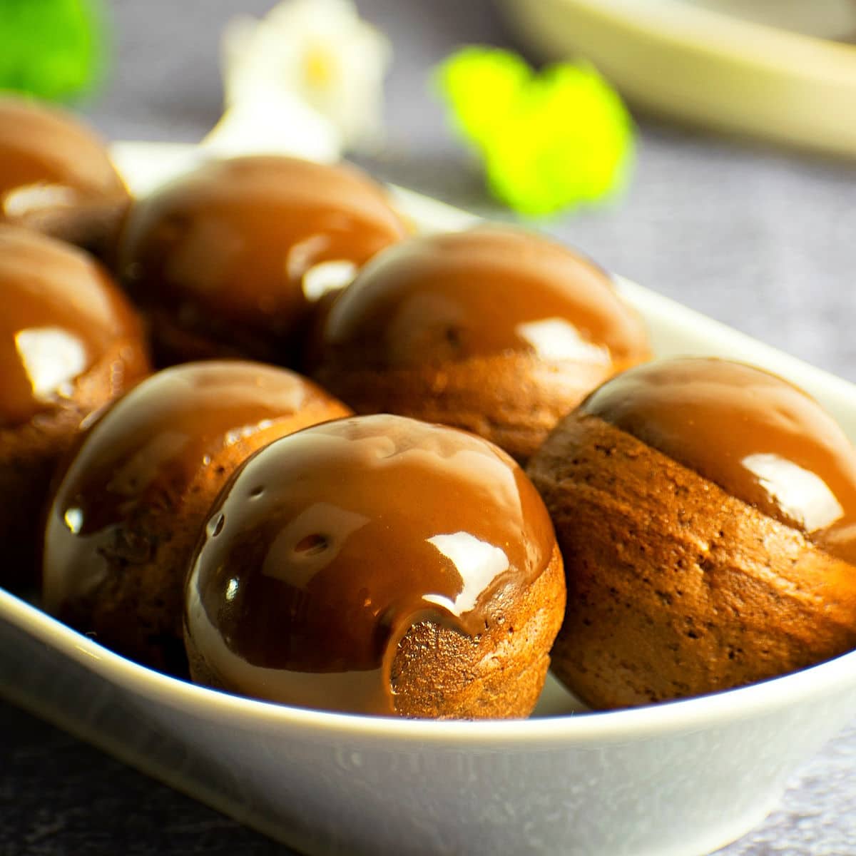 Chocolate covered donut holes on serving tray.