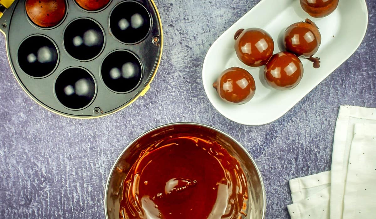 Donut holes on tray with bowl of chocolate.