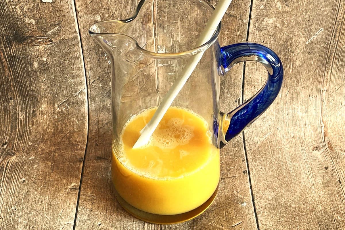 Mai Tai ingredients in glass pitcher with spoon.