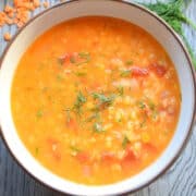Red lentil and dill soup in bowl.