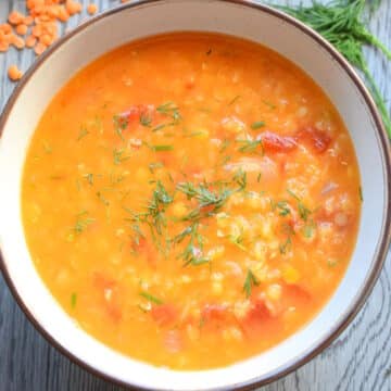 Red lentil and dill soup in bowl.