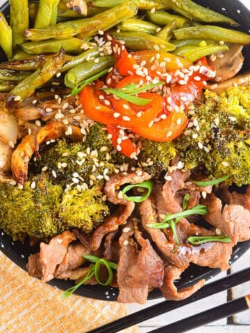 Beef and broccoli in black bowl.