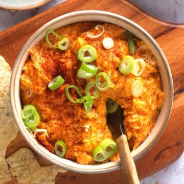 Buffalo chicken dip with green onions in serving dish.