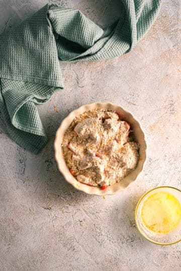 Strawberry crumble ingredients in tart dish.