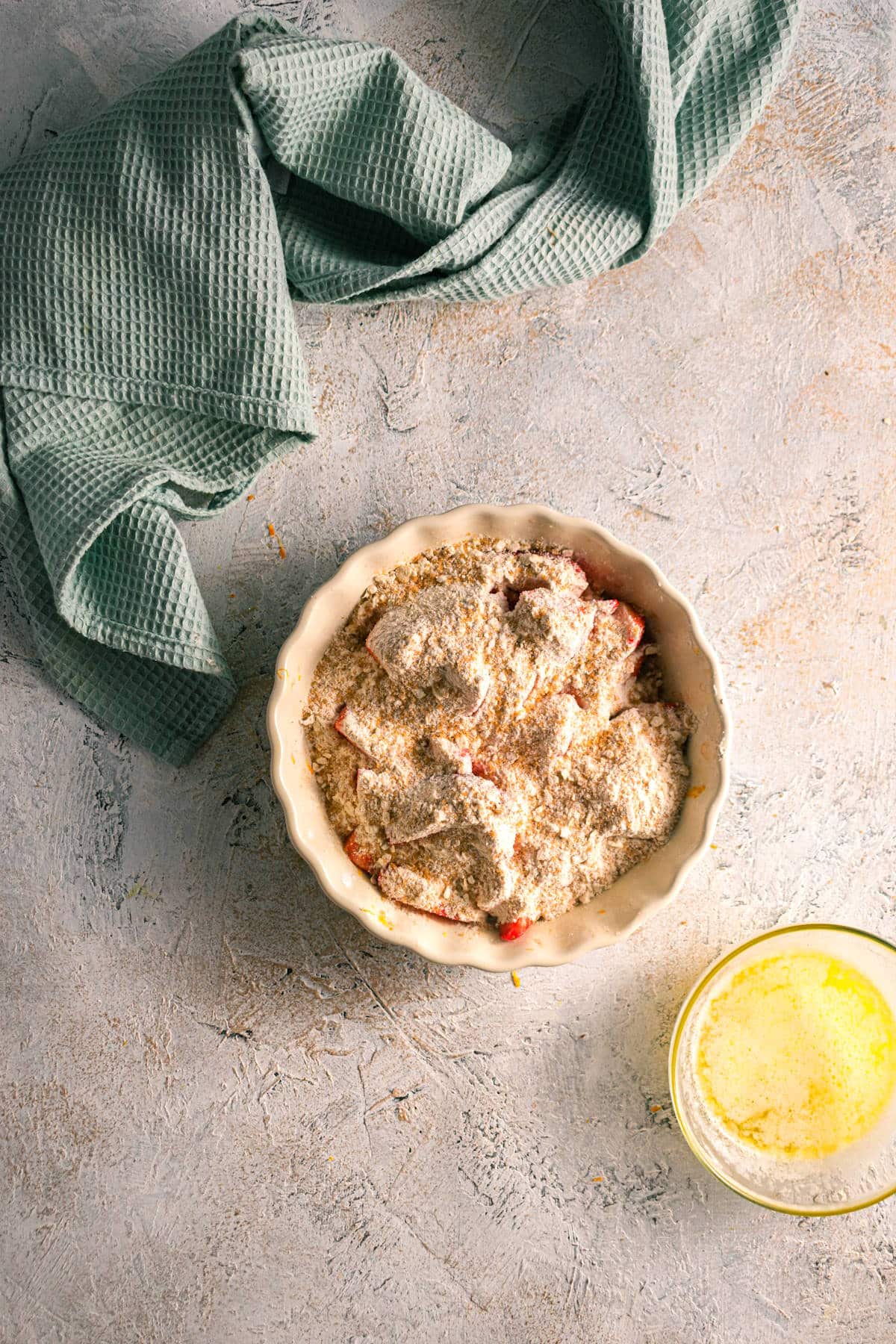 Strawberry crumble ingredients in tart dish.