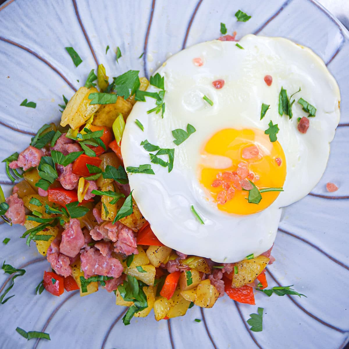 Electric skillet breakfast sausage and egg hash on plate.