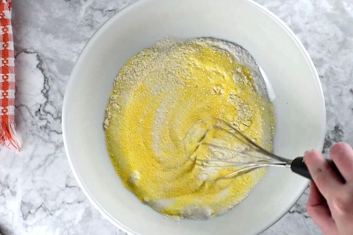 Cornbread dry ingredients whisked in bowl.