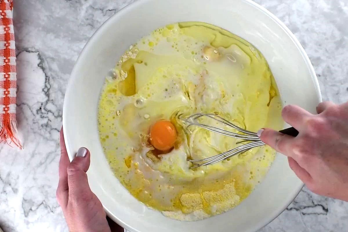 Cornbread batter getting whisked in bowl.