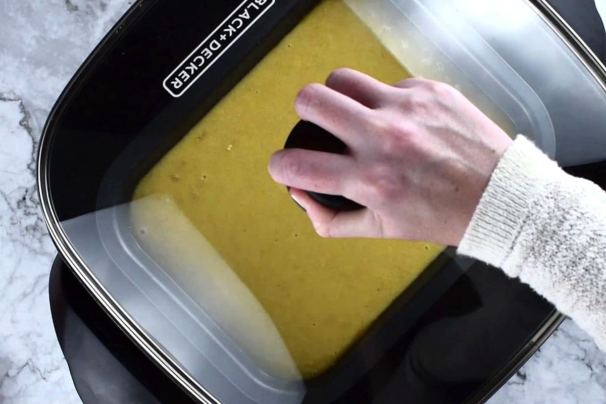 Cornbread baking in electric skillet with lid on.
