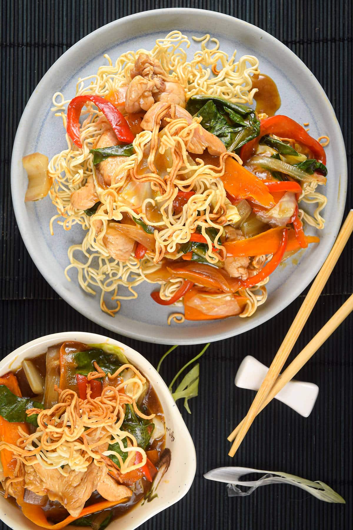 Crunchy chow mein noodle dish in white dishes with chopsticks on the side.