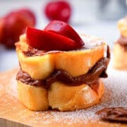 Electric skillet French toast stuffed with Nutella and topped with sliced apples and icing sugar.
