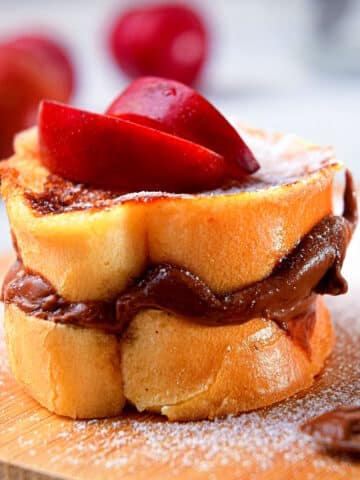 Electric skillet French toast stuffed with Nutella and topped with sliced apples and icing sugar.