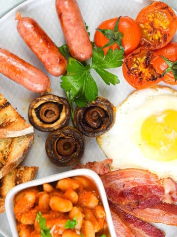 Full English breakfast on white plate.