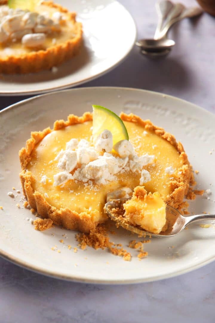 Key lime pie on plate with a spoon in it.