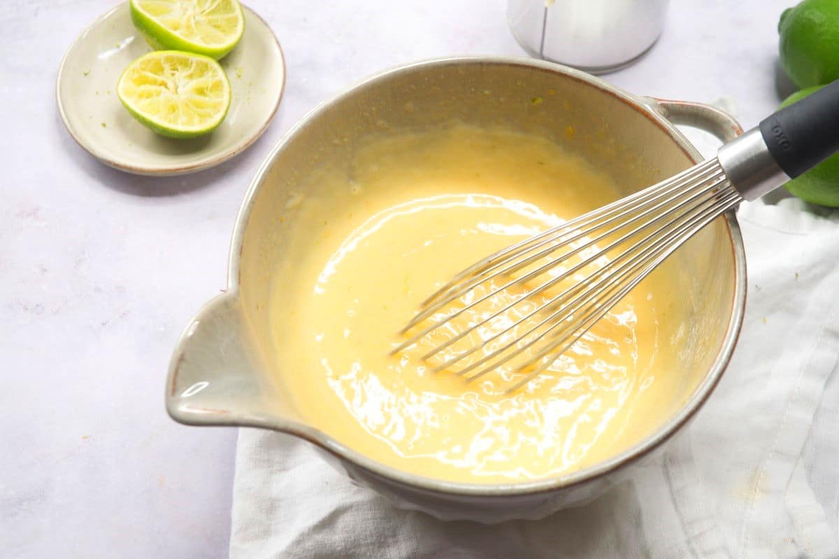 Key lime pie filling in bowl with whisk.